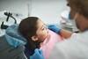 Kind auf dem Zahnarztstuhl wird untersucht