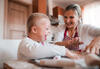 Kind mit Down-Syndrom backt lachend Plätzchen mit seiner Mutter