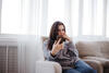 Frau mit Smartphone auf dem Sofa