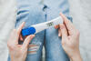 Frau hält positiven Schwangerschaftstest in der Hand