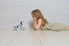 Mädchen liegt auf dem Boden und guckt Smart-Toy-Hund an