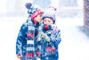 Zwei Kinder im Schnee flüstern