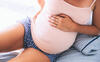 Schwangere Frau hält sich den Bauch