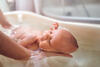 Mann badet Baby
