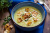 Pastinakensuppe mit gerösteten Pastinakenscheiben und Kräutern in einer Bowl