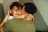 Sohn umarmt liebevoll seinen Vater mit geschlossenen Augen