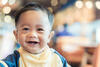 Baby mit zwei Milchzähnen lacht fröhlich in die Kamera
