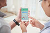 Arzt und Patient schauen sich Gesundheitsdaten auf dem Smartphone an