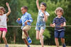 Vier Kinder spielen auf einer Wiese mit einem Seil