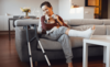 Frau mit Krücken entspannt sich auf dem Sofa