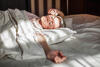 Frau räkelt sich nach dem Aufwachen im Bett