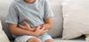 Porträt eines kleinen Jungen, der unter Bauchschmerzen leidet und seinen Bauch berührt