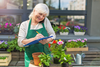 Seniorin bei der Arbeit in einem Gartencenter