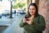 Junge Plus-Size-Frau mit Smartphone