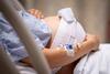Schwangere liegt im Krankenhausbett in den Wehen